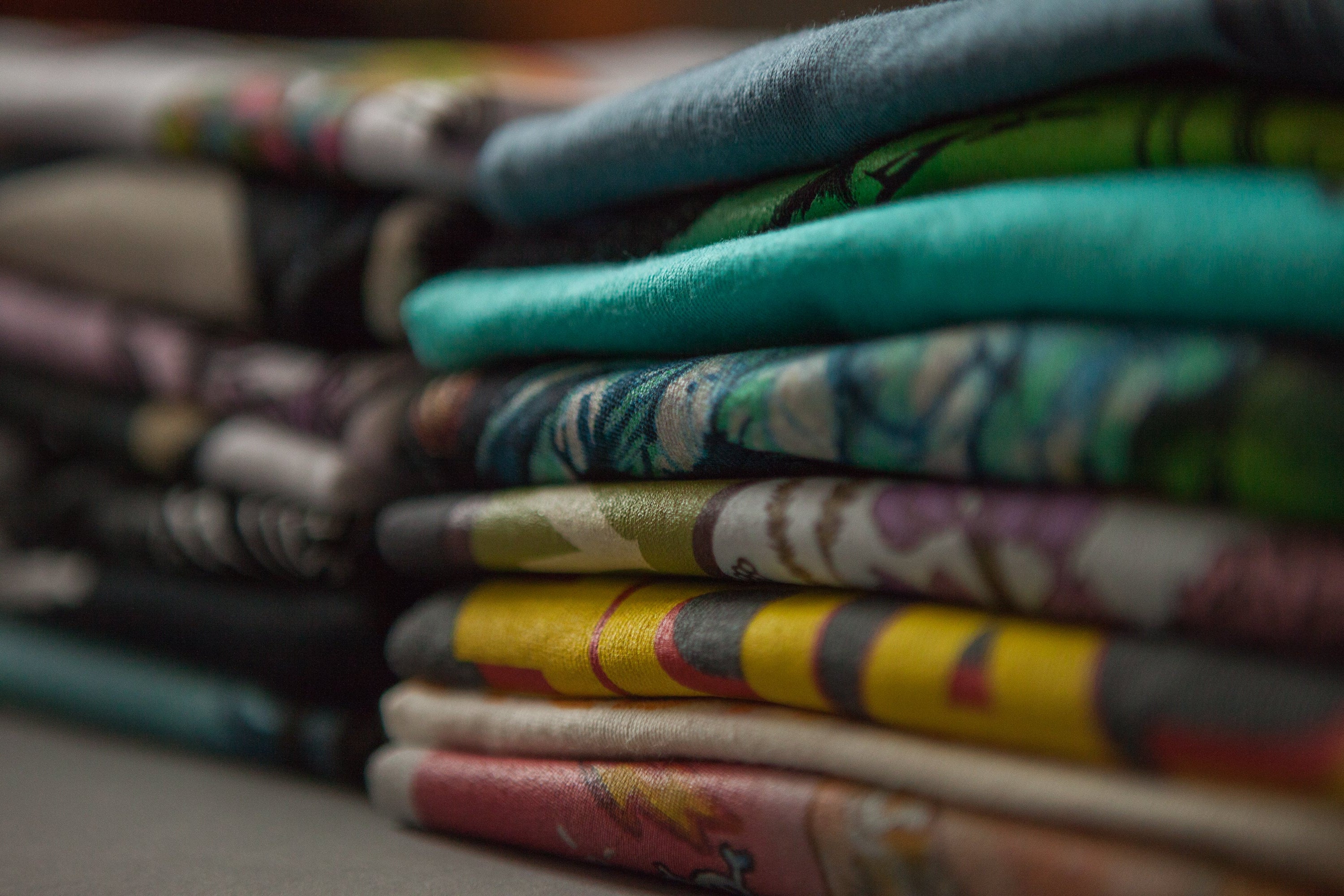 Stack of colorful folded fabrics with a blurred background